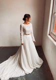 A bride wearing a two piece cream bohemian lace wedding dress. The lace top is long sleeve and the chiffon skirt is high waisted. This two piece lace dress is perfect for boho themed weddings and elopements.