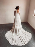 A bride wearing a two piece bohemian lace wedding dress. The ivory lace top is long sleeve and the chiffon skirt is high waisted. This two piece lace dress is perfect for boho themed weddings, rustic weddings and elopements.