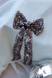 Add a touch of elegance and sparkle to any special occasion with our Luxury Sequin Hair Bow. Measuring a striking 6 inches wide by 10 inches long, this dazzling bow makes a perfect statement piece for weddings, parties, and festive celebrations. Available in captivating purple, classic black, and shimmering silver sequined fabric, it complements any outfit beautifully. Each bow is intricately adorned with high-quality sequins that catch the light, creating a radiant effect to elevate your look.