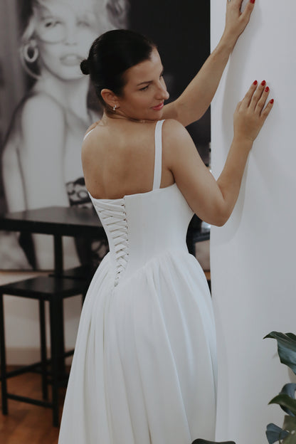 Introducing Hope - a newest addition to our luxury crepe wedding dress collection. &nbsp;Basque waist wedding dresses are leading the bridal fashion trends this year, with their signature V-shaped waistline captivating brides everywhere. Our luxury crepe basque waist bridal gown beautifully blends timeless charm with contemporary elegance, designed to make any bride feel exquisite. Crafted from premium crepe fabric, this gown offers a smooth, graceful drape that complements its striking silhouette.