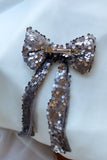 Add a touch of elegance and sparkle to any special occasion with our Luxury Sequin Hair Bow. Measuring a striking 6 inches wide by 10 inches long, this dazzling bow makes a perfect statement piece for weddings, parties, and festive celebrations. Available in captivating purple, classic black, and shimmering silver sequined fabric, it complements any outfit beautifully. Each bow is intricately adorned with high-quality sequins that catch the light, creating a radiant effect to elevate your look.